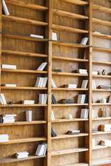 Large wooden bookshelves with books and minimal decor in modern loft library, cabinet or study interior. Natural wood texture, stylish workspace or reading area, contemporary office or business room