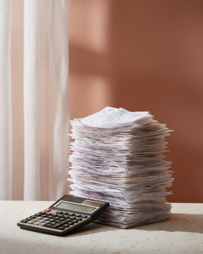 Tax season receipt paper document finance accounting calculator office stack budget Tall stack of receipt paper document for finance accounting near calculator office desk during tax season