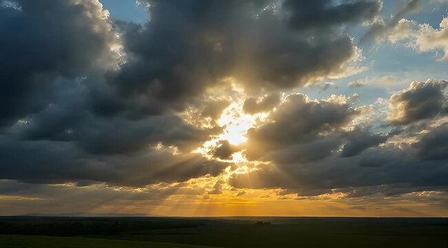 Dramatic golden sunset sky with sun rays beaming through billowing clouds