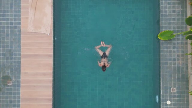 Woman swimming backstroke in a private pool