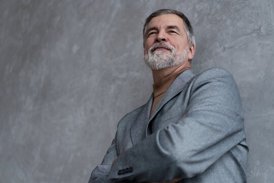 Entrepreneur in jacket smiling, Happy mid adult, mature age man standing, smiling, isolated on grey background
