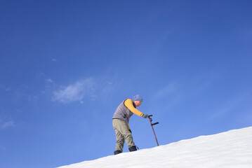 雪国で田舎暮らしの老人が杖を使ってリハビリをしている