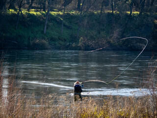 Fly Fisherman Casting Line in River