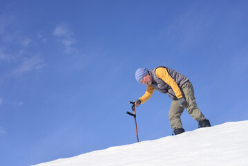 雪国で田舎暮らしの老人が杖を使ってリハビリをしている