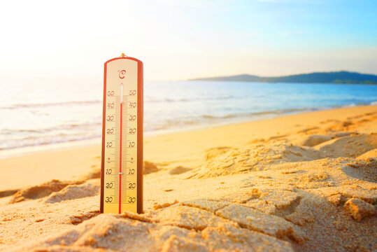 Thermometer on sunset sea beach in tropical. Extremely hot day. Thermometer measuring air temperature. Heat wave weather. Hot weather, drought. Abnormally temperature, extreme heat in Europe. Sunburn.