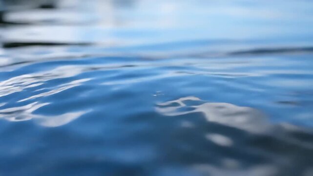 Closeup of Rippling Water Surface Reflecting Sky and Clouds.