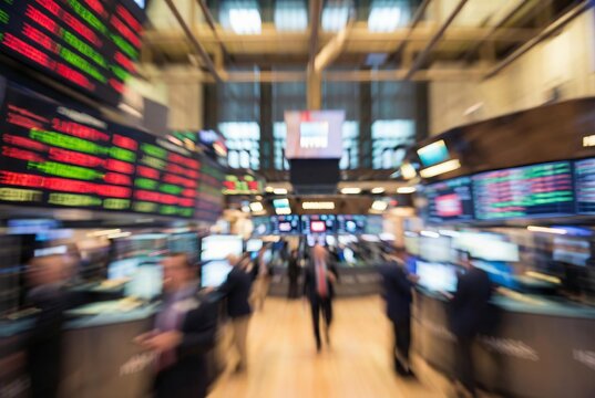 Blurry motion of traders working in a busy stock exchange with digital displays