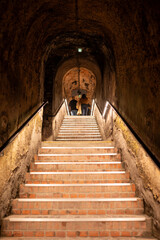 Obraz premium Visit of deep and long underground caves tunnel and stone bricks staircase, traditional method making champagne sparkling wine in Reims, Champagne, France