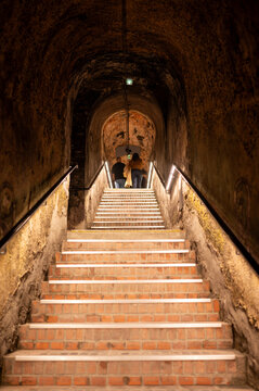 Visit of deep and long underground caves tunnel and stone bricks staircase, traditional method making champagne sparkling wine in Reims, Champagne, France