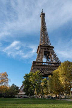 Walking in Paris in autumn, view on part trees and iconic Eiffel tower in daytime