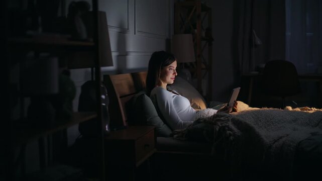Lady surfing internet bedtime lying cozy dark bedroom. Freelancer reading email