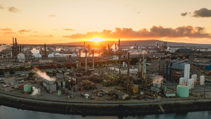 Fototapeta premium Aerial view of an oil refinery at sunset with distillation towers and processing units