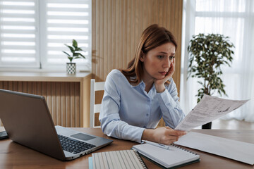 Woman reading document at home office desk