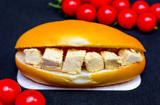 Delicious sandwich with halawa and cherry tomatoes on dark background