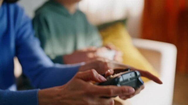 Child hands pressing console at video game competition with young mother closeup