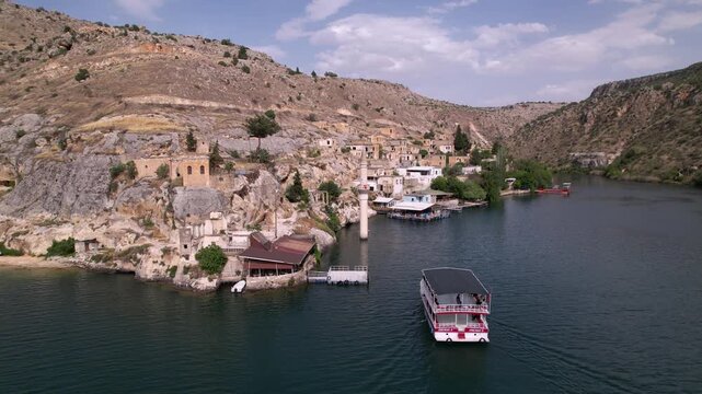 Experience a cinematic flight over the iconic half-submerged minaret of Savaşan Village in Halfeti. This footage highlights the haunting ruins and the turquoise depth of the Euphrates River.