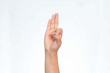 Naklejka premium A close-up shot of an Indonesian woman's hand gesturing with three fingers raised and thumb holding the pinky, isolated on white background. 