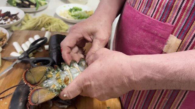 Preparing a live Shanghai hairy crab at home, with a cook cutting the crab using a large cleaver on a wooden cutting board to remove the meat from the hard shell before steaming in a kitchen setting.
