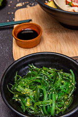 Wakame seaweed prepared as a salad, showing its characteristic moist appearance after rehydration and dressing.