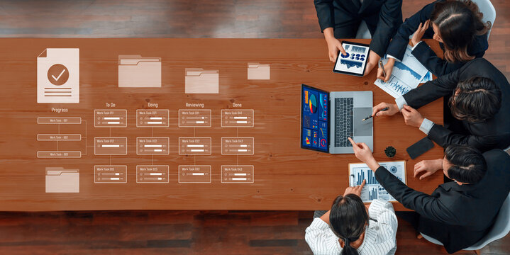 A modern office scene showcasing a team engaged in a business meeting, analyzing data using charts and technology to strategize and enhance project management efficiency. Trope