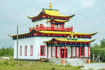 Obraz premium Traditional buddhist temple with colorful decorations and golden roof, located in the serene landscapes of russia, showcasing the country's religious diversity