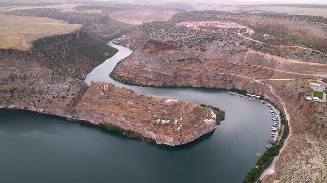 Drone flight over Rumkale, a historic archaeological site on the Euphrates and Merzimen confluence. Ancient Mesopotamian ruins and turquoise water. Cinematic travel scenery.