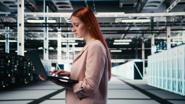 Optimizing electronics, laptop and woman in server farm doing improvements. Monitoring system performance, notebook and female technician walking in data center, identifying bottlenecks, camera A