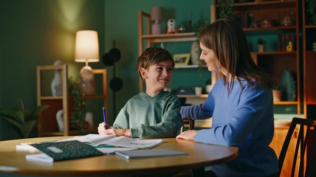 Happy mother son teaching home together closeup. Woman supporting schoolboy 