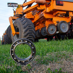 Obraz premium Industrial ball bearing on rural road at sunset: Logistics and field repair concept
