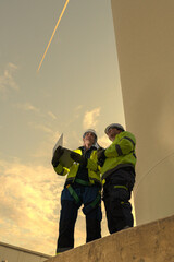 Obraz premium Visionary green collar workforce managing sustainable wind power grid at sunset. Dedicated engineers committed to global ESG and decarbonization.