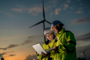 Smart energy solutions. Engineers using advanced tech and real-time data to optimize sustainable wind power at dusk. Driving the green innovation. © ultramansk