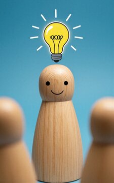 Wooden figure smiles as a glowing lightbulb idea shines above its