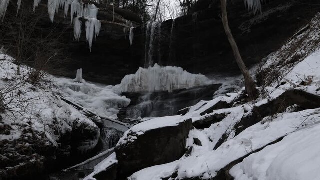 Frozen Waterfall with Icicles and Snow in Winter Forest at Tinker Falls New York