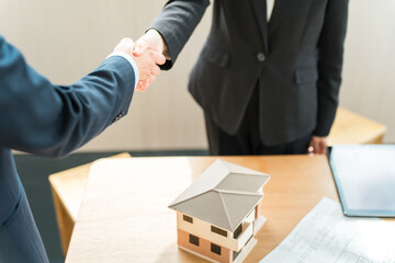 Businessmen in suits shaking hands in a conference room