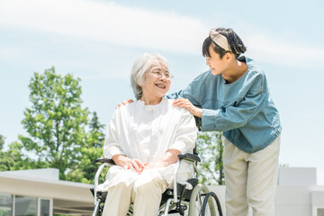 Obraz premium Senior woman in a wheelchair, grandmother and granddaughter visiting