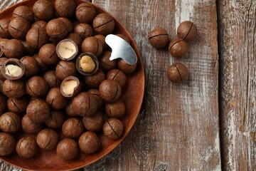 Fototapeta premium Macadamia nuts and metal key on wooden table, top view