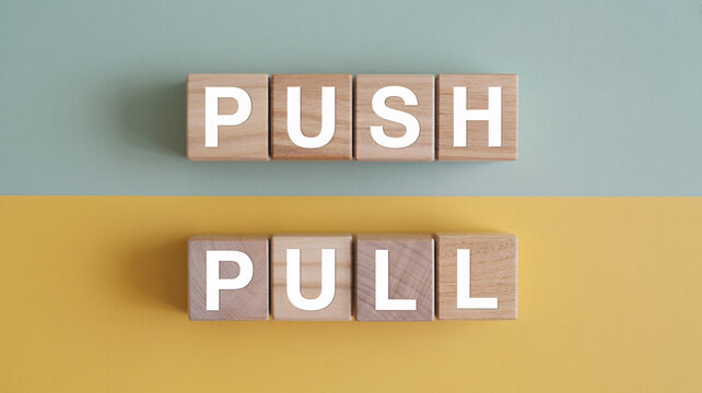 Wooden blocks spelling push and pull on colorful background