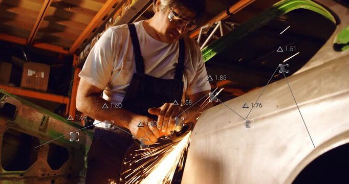Male mechanic starting grinder against fender seam in auto workshop, sparks flying, prepping panel