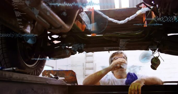 Mechanic lifting cup while scanning car underbody, starting auto check with HUD graphics appearing
