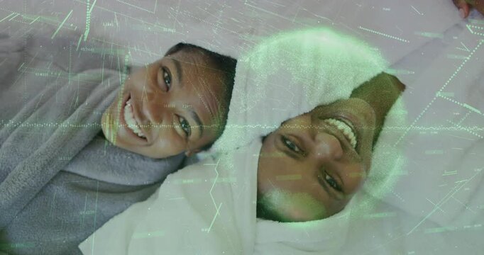 Mom-daughter lying heads on spa bed relaxing while play starting  and  green overlay scanning faces