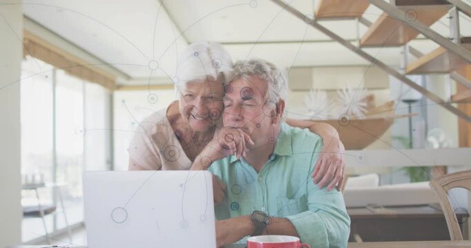Elderly couple opening laptop in living room, starting tech demo and watching animated charts
