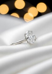 Elegant Diamond Ring on White Silk with Bokeh Background.