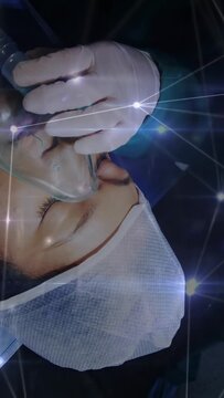 Vertical video: Provider placing and sealing clear mask on male patient for oxygen, sparkle overlay