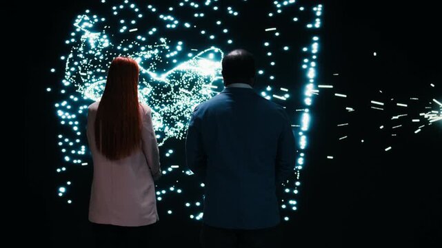 Monitoring AI model, AR projection and engineering team collaborating on cognitive systems. Studying neural network activity, laptop and coworkers in RD tech startup brainstorming, camera A