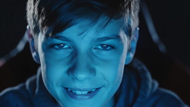 Young boy focused with intense blue screen light on face
