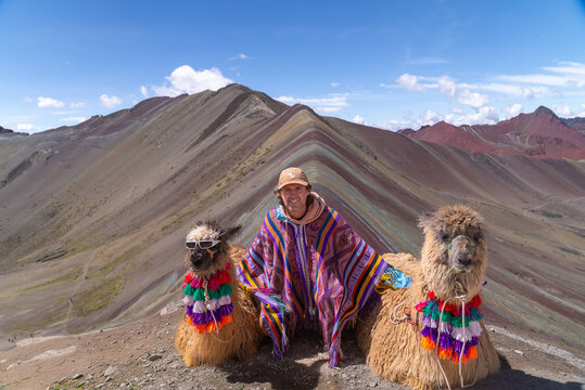 Rainbow Mountain llamas cool glasses tourist Vinicunca Monta&ntilde;a de Siete Colores Peru Per&uacute;  Peruvian Andes seven colored mountains melted glacier Winikunka Vilcanota Cusco Region morning blue sky cloud