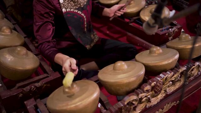 Traditional Indonesian Gamelan Musician Playing Bonang Instrument