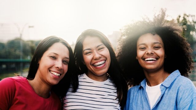 Diverse young women having fun looking at camera outdoor - Young people, friendship relationship concept