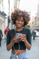 Naklejka premium Young woman enjoying music outdoors.