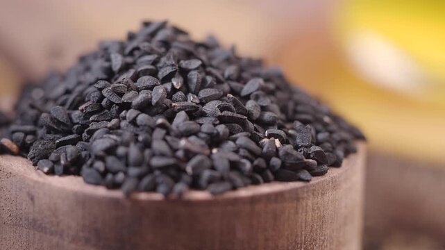 black cumin seeds in a wooden spoon 